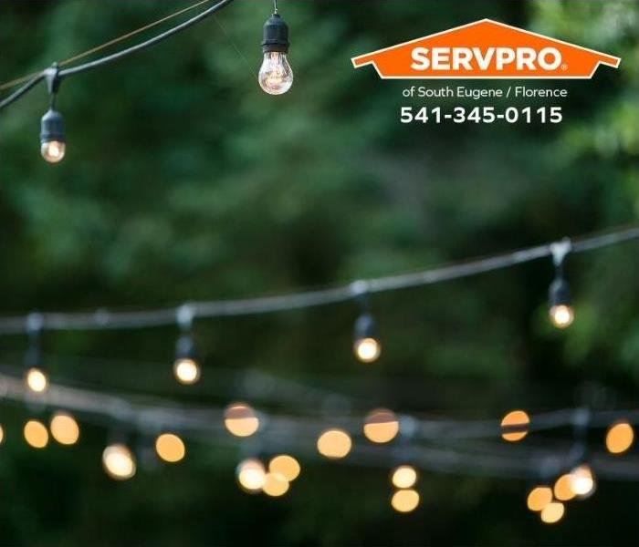Strings of outdoor party lights and lit in preparation for a garden party.