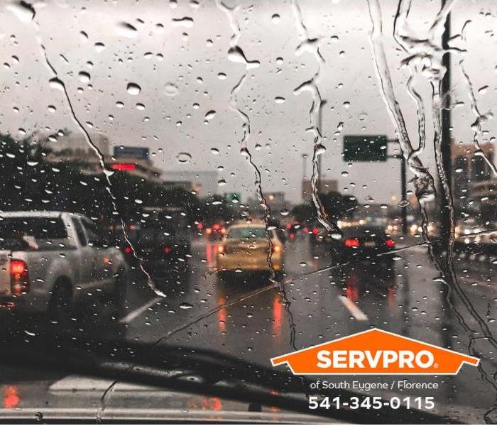 Traffic conditions in heavy rain in a commercial area are shown.